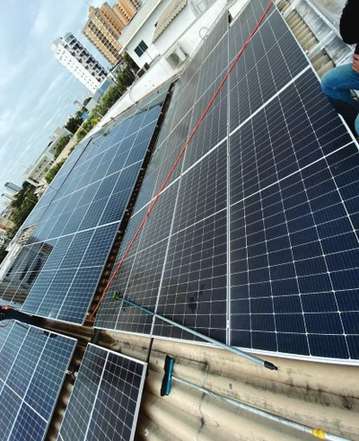 Fileiras de módulos fotovoltaicos durante serviço de manutenção.
