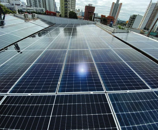 Usina solar de porte comercial instalada sobre laje, vista do nível dos módulos.